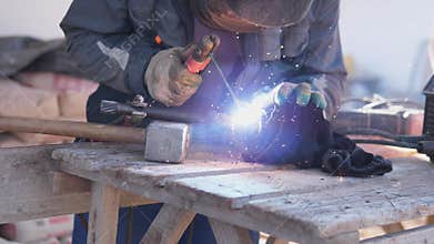 Welding Sparks Fly. Bright Arc Illuminates Bustling Workshop Scene. Experienced Tradesperson Uses Arc And Protective
