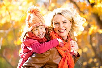 Smiling parent and kid family walking together outdoor in fall