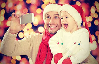 Selfe in Christmas. happy family dad with daughter and photographed on mobile phone