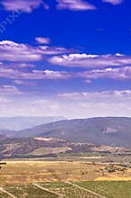 Mountain range with snow-white clouds on a blue sky