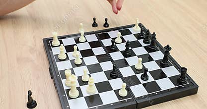 Woman plays chess solo and plans tactic for next move on board