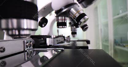 Modern microscopes neatly arranged on laboratory table