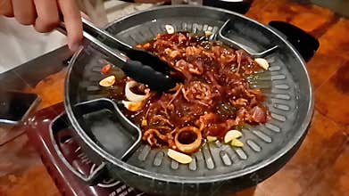 Slow Motion Stirring Marinated Korean BBQ Meat on a Sizzling Grill