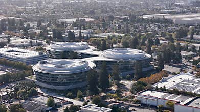 Wide aerial view of the Apple Wolfe Campus, a tech headquarters surrounded by the suburban landscape of Silicon Valley