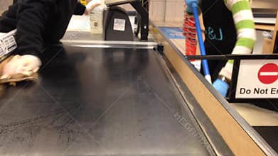 Cashier cleaning the checkout food belt