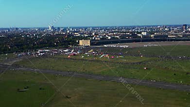 People flying colorful giant kite at festival. Dramatic aerial view flight drone