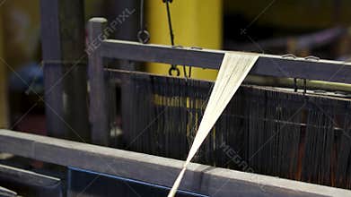 Discover the artistry of traditional weaving as skilled artisans manipulate threads on looms, creating stunning fabrics