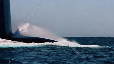 Advanced combat ship demonstrates its high-speed capability on open water during mission. Military submersible surges forward
