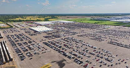 New cars parked on automotive factory parking lot for worldwide export. Dealer vehicle inventory business commercial.