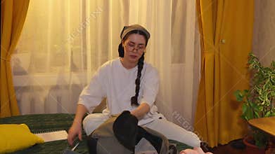Female student arranges clothing and accessories on bed folding and packing items for upcoming holiday journey. Mid shot