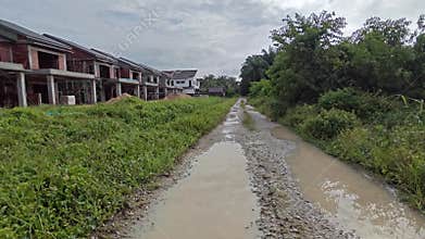 stagnant pool of rainwater along the diminishing perspective rural pathway into the rural countryside