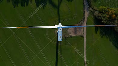 Wind turbine shadow generating clean energy autumn. Dramatic aerial view drone