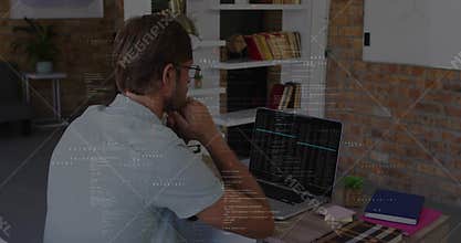 Studying mid-adult man analyzing code on laptop at home office, with shelving succulent notebooks