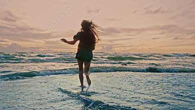 Beautiful Silhouette of Young Woman Running at Ocean Beach to Summer Sea Water