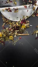 Herbal tea blend with chamomile, melissa, and hibiscus on black background
