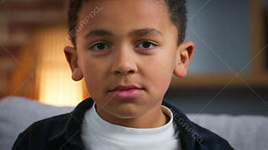 Portrait serious little African American boy at home looking at camera ethnic son child pupil baby kid schoolkid upset
