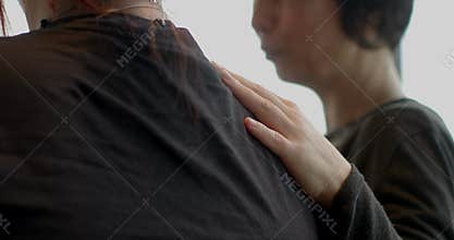 Female friend assists with jacket fitting as they prepare for city walk