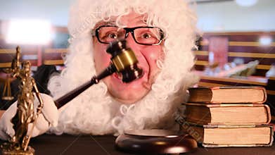 Crazy judge with wig holding gavel and laughing in courtroom.