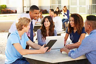 High School Students Working On Campus With Teacher