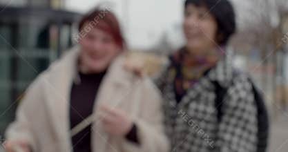 white bride-to-be and asian friend secret handshake sidewalk prague
