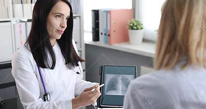 Woman doctor shows chest X-ray on tablet and explains risk