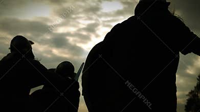 Medieval battle . Silhouettes of warriors with swords,axes,shields