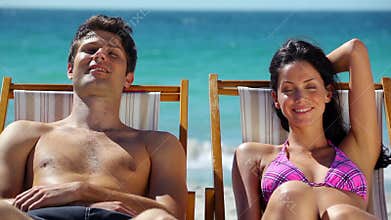 Couple resting on deck chairs