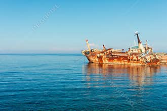 Rusty the Edro III Shipwreck, Pegeia, Cyprus, resting by calm blue sea under clear sky at distant horizon