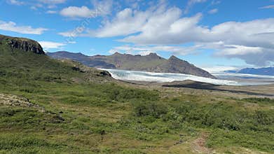 Expansive Icelandic Tundra with Green Patches and Distant Peaks