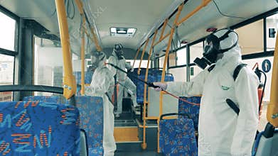 People in protective suits kill virus in a bus during disinfection.