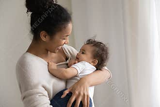 Caring african American mom lull small baby