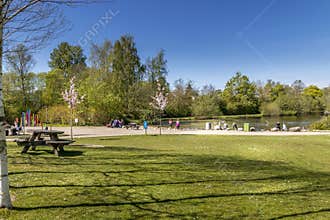 The Doctor Park in Randers. people sit and drink coffee in nature. picnic in the park. lake and forest in the background