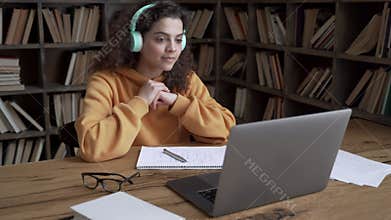 Hispanic teen girl student wear headphones watching online webinar on laptop.