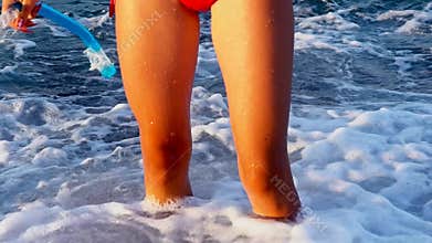 Beach vacation of girl barefoot by sea foam wave