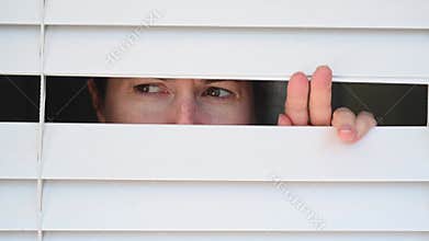 Suspicious person looking outside home window