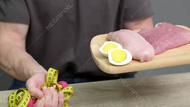 Healthy eating concept. Man of athletic build eats healthy food high in protein