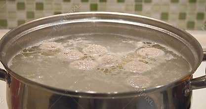 Boiling broth for soup with meatballs in a pot