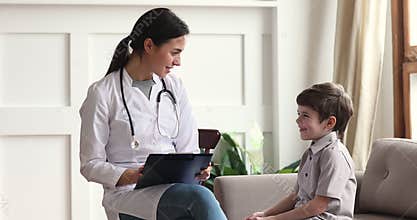 Friendly pediatrician giving high five to small child boy patient.