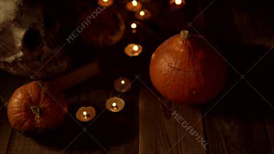 Still life of pumpkins and skulls on a wooden table when the candles go out