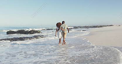 African American couple walking seaside