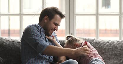Happy young father parent tickling small laughing kid daughter.