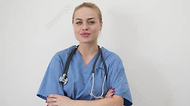 Female doctor in blue medical coat standing isolated with arms crossed. Looking at camera