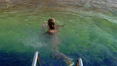 Start of summer season happy girl falling in swimming pool