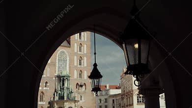 Ancient forged street lamp, hanging in an arch in the distance birds fly by