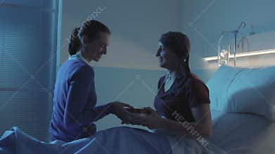 Caring woman visiting her sick friend at the hospital