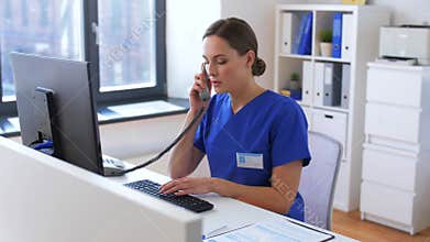 Doctor with computer calling on phone at hospital