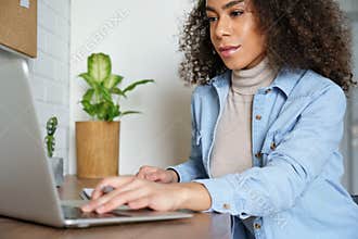 African teen girl distance learning online watching webinar on laptop computer.