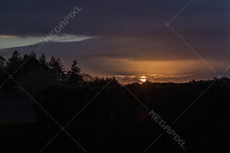 Beautiful spring sunrise silhouetting the trees on the horizon