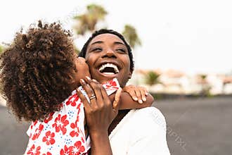 Happy African family on the beach during summer holidays - Afro American people having fun on vacation time