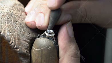 Diamond ring making. jeweler putting ring on ring close up. handmade diamond ring production.